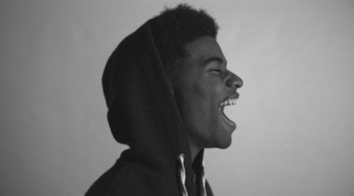 Young black man in hoodie in profile